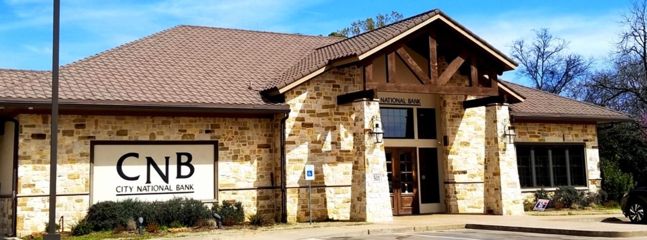 White and brown stone building with large doors and windows. Quitman Branch