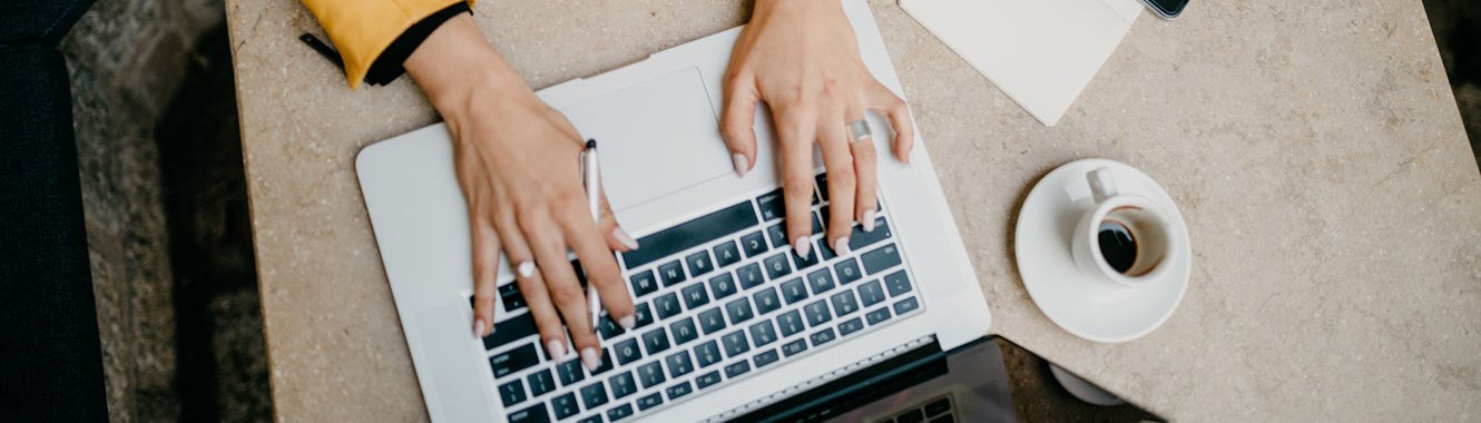 Woman typing on a laptop.