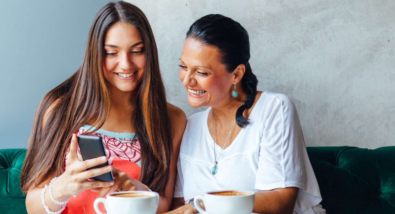 A mother and daughter looking at mobile banking
