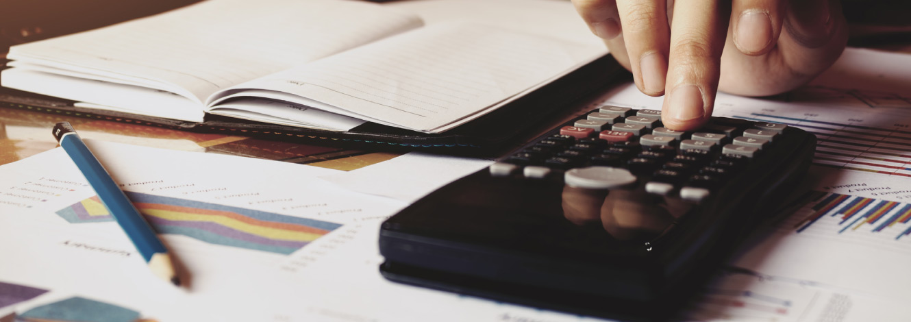 Person sitting at a desk using a calculator