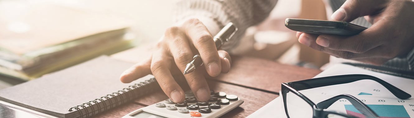 Woman typing numbers into a calculator.