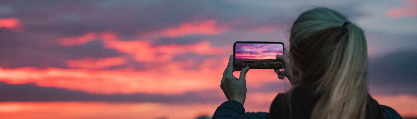 woman taking picture of sunset cnb calendar contest